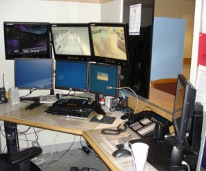 A dispatch station with multiple monitors and a phone system
